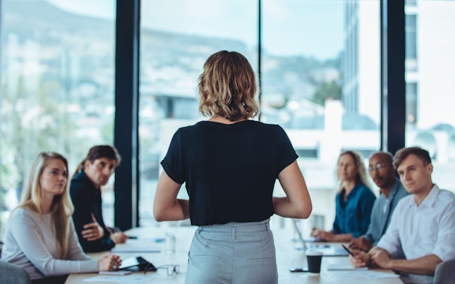 businesswoman-making-a-presentation-to-her-colleagues-in-office.cdn